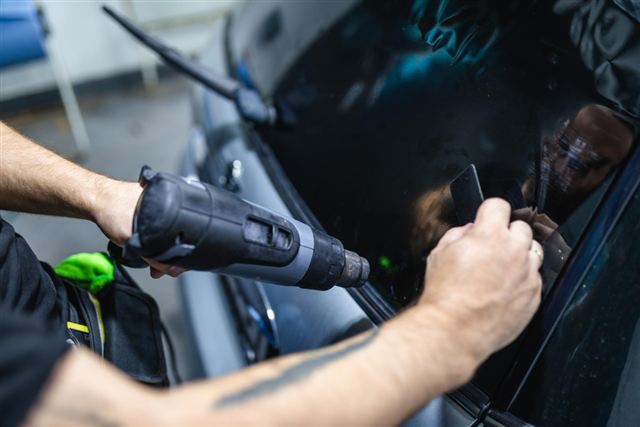 متخصص يطبّق تظليل حراري على زجاج السيارة — خدمة 3M Car Care